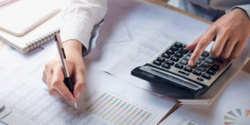 finance-and-accounting-concept-business-woman-working-on-desk-using-calculator[1]